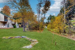 A residential area with a well-maintained lawn, a pathway, and a variety of trees in autumn colors. - 2BR condo w/ fireplace, ski locker, pool, sauna, tennis (Waitsfield)