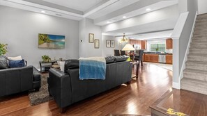 A modern living room with a sofa, a coffee table, and a painting on the wall. - Disney Retreat With Resort Pool and Spa Access (Orlando)