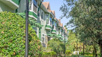 A residential area with a pathway leading to a row of houses with green and white trim.