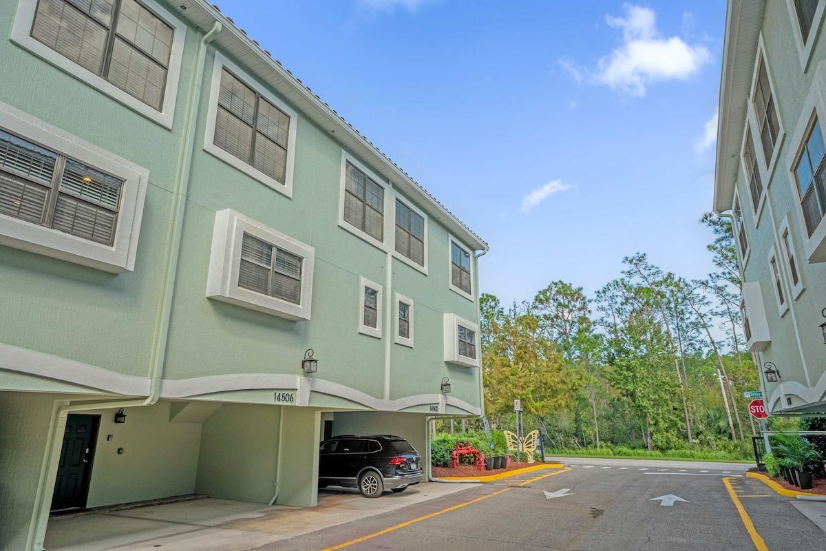 A multi-story building with a garage entrance, a stop sign, and a clear sky.