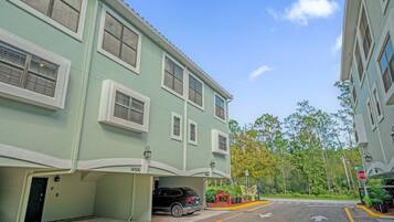 A multi-story building with a garage entrance, a stop sign, and a clear sky.