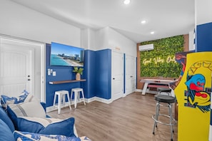 Ein moderner Wohnraum mit blau-weißer Farbgebung, einer Küchenzeile und einer Bar mit Hockern.