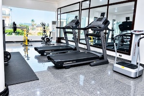 A gym with treadmills, a stationary bike, and weightlifting equipment.