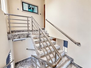 A staircase with marble steps and metal handrails, leading to an upper floor. - Grand Pallazzo Hotel and Suites (Owerri)