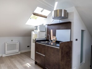 A modern kitchen with a skylight, built-in microwave, and a stainless steel range hood. - Cozy Accommodation, Central Madrid (Madrid)