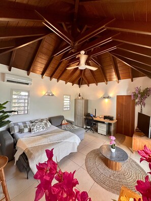 A bedroom with a bed, desk, chair, and a ceiling fan. - Villa des Rocher – Private Jacuzzi, Ocean View, and Serenity in Saint Barth (Grand Fond)