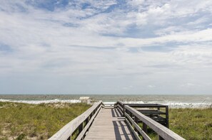 A wooden boardwalk leading to the beach with a clear view of the ocean and sky. - Cozy 1 BR in Sea Mist! (Carolina Beach)
