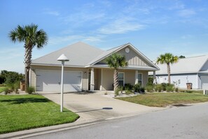 A residential house with a garage, a driveway, and a lawn. - 🌴Sweet 'N Salty | Walk to Beach | Community Pool🌴 (WindMark Beach)