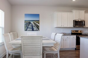 A modern kitchen with white cabinetry, a stainless steel microwave, and a built-in oven. - 🌴Sweet 'N Salty | Walk to Beach | Community Pool🌴 (WindMark Beach)