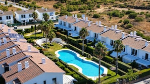 A residential area with multiple houses, a swimming pool, and well-maintained gardens. - Apartment in El Rompido with a pool | 3 bedrooms | 3 bathrooms (El Rompido)