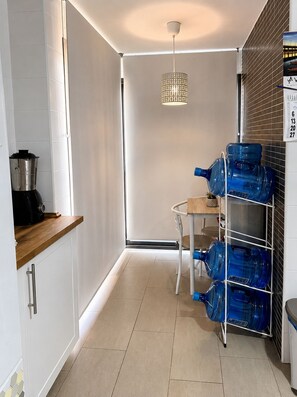 A kitchen with a coffee maker, a water dispenser, and a hanging light fixture. - Apartment in El Rompido with a pool | 3 bedrooms | 3 bathrooms (El Rompido)