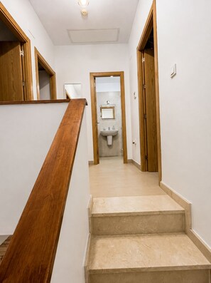 A staircase leading to a bathroom with a sink and mirror. - Apartment in El Rompido with a pool | 3 bedrooms | 3 bathrooms (El Rompido)