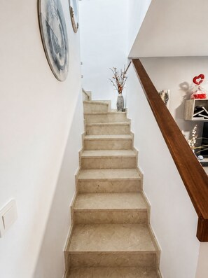 A staircase with a wooden handrail leading to a landing. - Apartment in El Rompido with a pool | 3 bedrooms | 3 bathrooms (El Rompido)