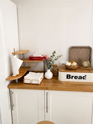 A kitchen counter with a bread box, a jar of corks, a bowl of pumpkins, and a clock. - Apartment in El Rompido with a pool | 3 bedrooms | 3 bathrooms (El Rompido)