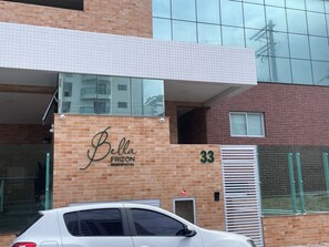 A building with a sign reading 'Bella Frizon Residencial' and the number '33' on the facade. - 2 bedroom apartment, 1 suite, perfect location, new building, beachfront, downtown. (Mongaguá)