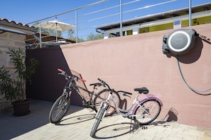 Ein Fahrrad, das an einer Mauer geparkt ist, mit einer Trinkbrunnen in der Nähe.
