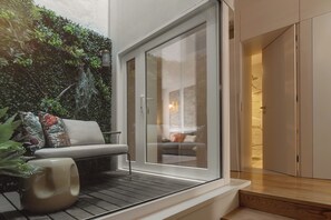 A modern bathroom with a glass shower enclosure, a bench with cushions, and a wall of greenery. - NEW: Bloom Porto | Luxury Clérigos Gem with Patio (Unknown)