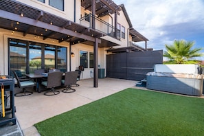 A modern house with a patio area featuring outdoor furniture and a well-maintained lawn. - Snow Canyon Oasis #66 3 Bedroom Townhouse (Santa Clara)