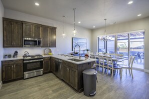 Una cocina moderna con electrodomésticos de acero inoxidable, armarios de madera y un comedor con vistas.