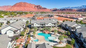A residential area with houses, a swimming pool, and a mountain in the background. - Snow Canyon Escape Private Pool #65 5 Bedroom Townhouse (Santa Clara)