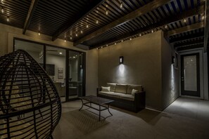 A modern interior with a sofa, a hanging chair, and a table. - Snow Canyon Escape Private Pool #65 5 Bedroom Townhouse (Santa Clara)