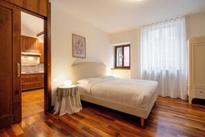 A bedroom with a bed, bedside table, and a window. - Residenza Adua - 100mt dall'Arena  (Verona)