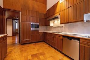 A modern kitchen with wooden cabinets, a stainless steel refrigerator, an oven, a dishwasher, and a gas stove. - Residenza Adua - 100mt dall'Arena  (Verona)