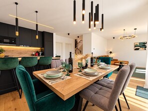 A modern dining area with a wooden table, green chairs, and pendant lighting. - Modern Villa Istria in Nedescina (Nedescina)