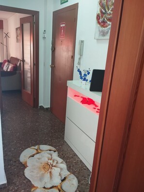 A hallway with a door marked 'EXIT' and a wall-mounted phone. - The El Tiburon vacation rental is located 70 meters from the beach and the Maritim Passeig. (Grau i Platja)