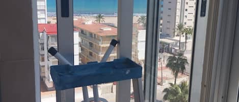 A balcony with a view of the beach and buildings.