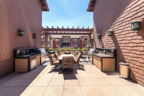 An outdoor patio with a grill, seating area, and a pergola. - New Listing! Riverstone Condo | Private Balcony | Walk to Shops and Dining (Coeur d'Alene)