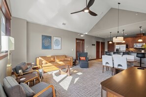A modern living room with a sofa, chairs, a coffee table, and a dining area with a table and chairs. - New Listing! Riverstone Condo | Private Balcony | Walk to Shops and Dining (Coeur d'Alene)