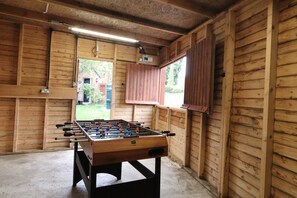 A wooden-floored room with a foosball table and a window with shutters. - Lincolnshire wolds cottage - private garden - games room - 30 mins from Lincoln (Ludford)