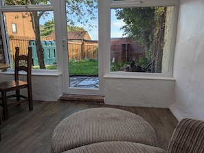 A room with a view of a wooden fence and a brick building through large windows. - Lincolnshire wolds cottage - private garden - games room - 30 mins from Lincoln (Ludford)