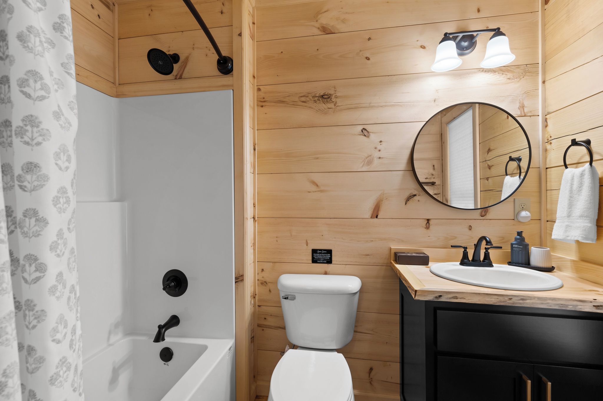 Une salle de bain équipée d’une baignoire, de toilettes, d’un lavabo et d’un miroir.