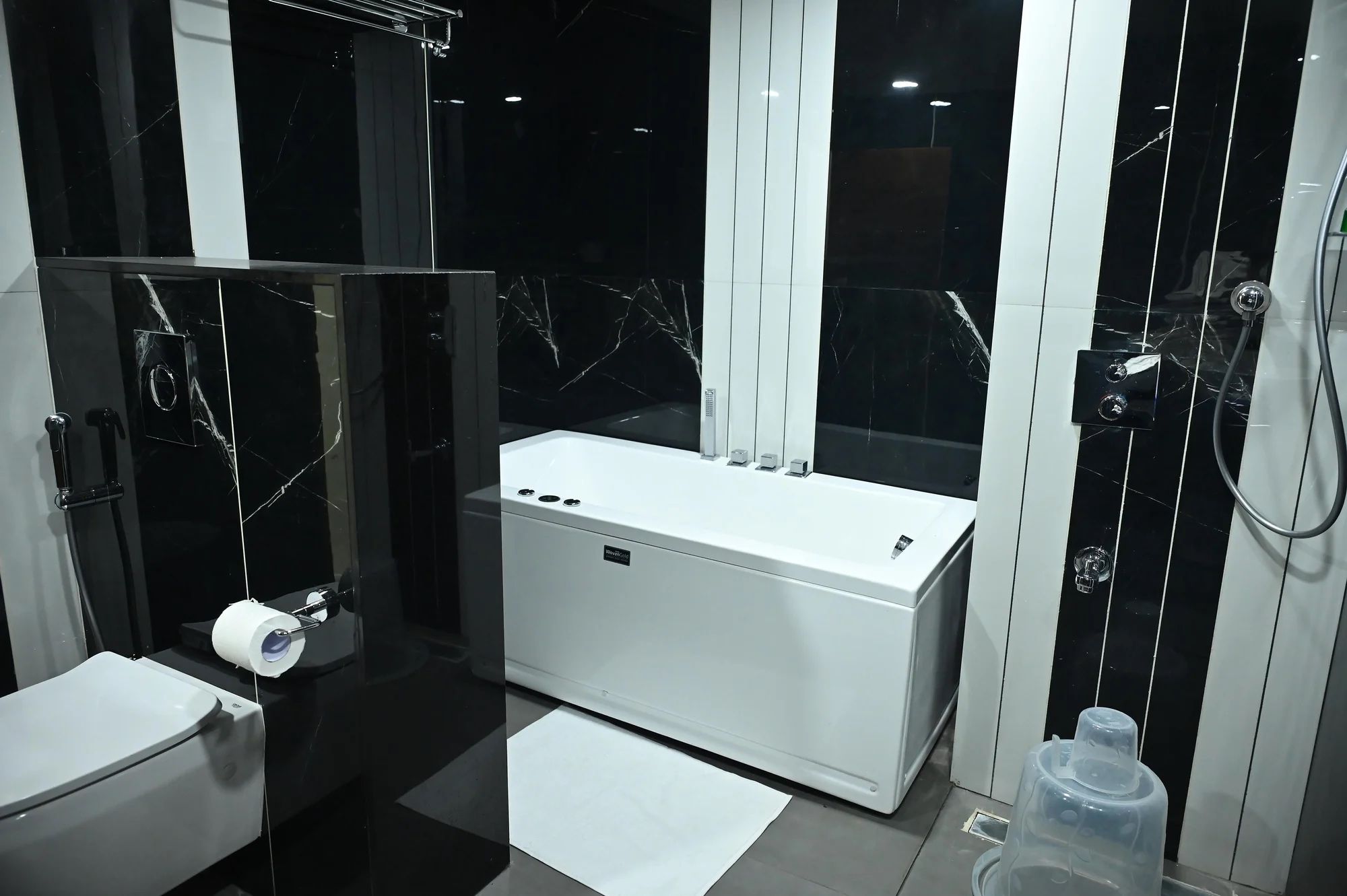A modern bathroom with a toilet, bidet, and a bathtub.
