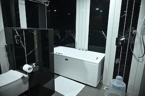 Ein modernes Badezimmer mit Toilette, Bidet und einer Badewanne.