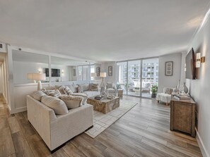Ein modernes Wohnzimmer mit einer Couch, einem Couchtisch und Blick auf den Balkon.