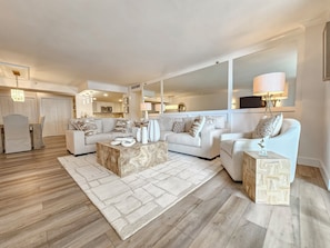 Ein modernes Wohnzimmer mit einer Couch, einem Couchtisch und einem Essbereich mit Stühlen.