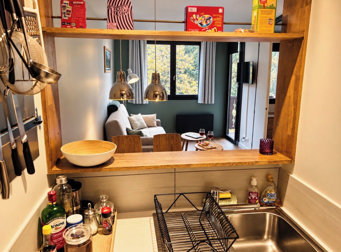 Una cucina moderna con un piano di lavoro in legno, un lavello e diversi utensili da cucina.