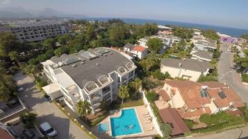 Zona residencial con un edificio grande que tiene piscina y varios balcones.
