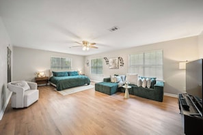 A bedroom with a bed, a sofa, a chair, a television, and a ceiling fan. - 3BR Near FSU/FAM | Golf Course (Tallahassee)