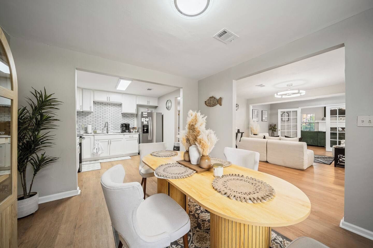 A modern kitchen with white cabinets, a built-in oven, and a refrigerator.