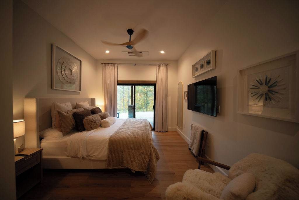 Een slaapkamer met een bed, een televisie en kunst aan de muren.