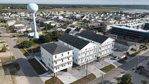 Ein Wohngebiet mit einem markanten Wasserturm, einem mehrstöckigen Gebäude mit Balkonen und einem großen Parkplatz.