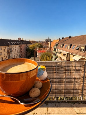 A balcony with a cup of coffee, a plate with cookies, and a striped fabric backdrop. - Vrbo Property (Basel)