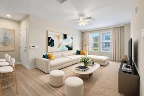 A modern living room with a sectional sofa, ottomans, a coffee table, and a flat-screen TV. - 2bedroom and 2bathroom fully furnished apartment (Tampa)
