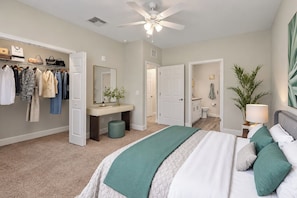 Un dormitorio con cama, tocador, armario y baño.