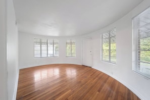 A room with wooden flooring, white walls, and three windows with blinds. - 4BR House Near FSU, Pet-Friendly (Tallahassee)