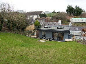 A modern house with a flat roof, large windows, and a small garden. - Modern Welsh cottage moments from the beach - Pass the Keys (Pentraeth)